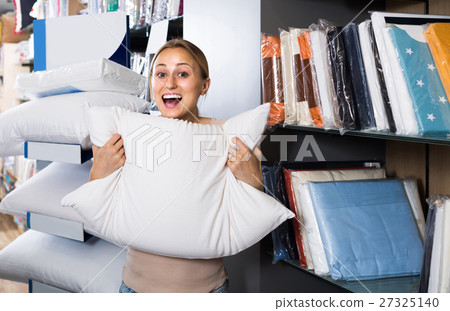 portrait of female customer choosing pillow in bedding section in shop portrait of female customer choosing pillow in bedding section in shop 27325140