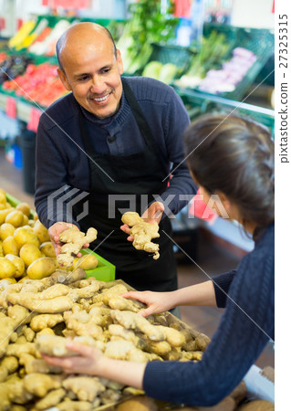 man helping customer to choose ginger 27325315