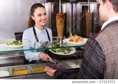 Friendly young female worker serving customer 27325351