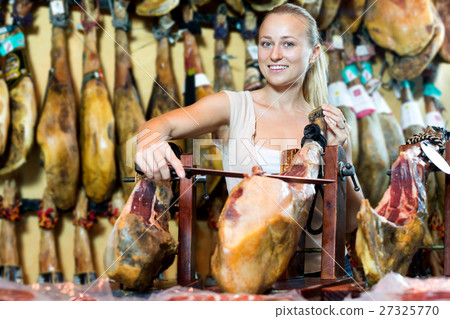Woman in uniform slicing delicious prosciutto meat Woman in uniform slicing delicious prosciutto meat 27325770