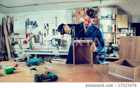 Male worker finishing to drill drawer 27325876