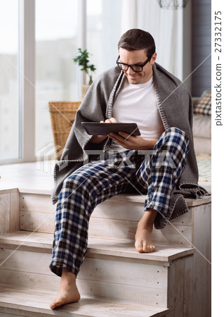 Pleasant attractive man sitting on the stairs Pleasant attractive man sitting on the stairs 27332175