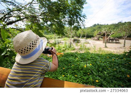 little kid taking photos at the zoo 27334063