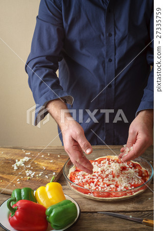 Man makes homemade pizza 27335759