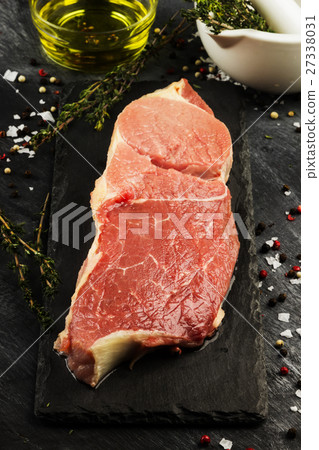 Piece of raw meat of beef on a slate board 27338031