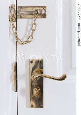 handle and chain on the white front door 27354707