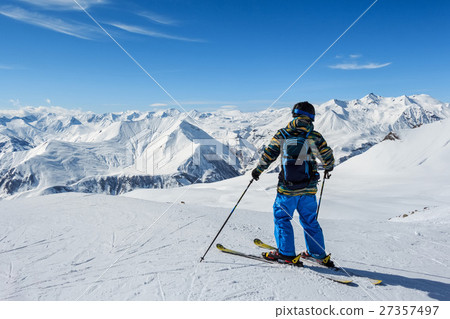 Skier standing in front of mountains Skier standing in front of mountains 27357497