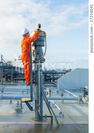 Engineer in orange workwear is testing pv valve. Engineer in orange workwear is testing pv valve. 27358045