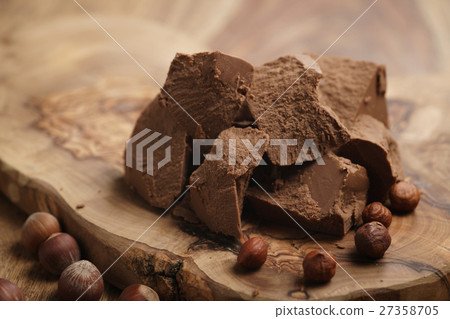 chunks of gianduja with hazelnuts on wood board chunks of gianduja with hazelnuts on wood board 27358705