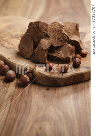 chunks of gianduja with hazelnuts on wood board chunks of gianduja with hazelnuts on wood board 27358707