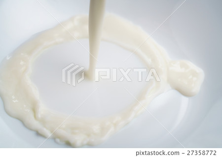 pouring milk into bowl from above pouring milk into bowl from above 27358772