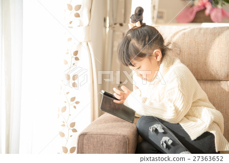 A girl watching a smartphone A girl watching a smartphone 27363652