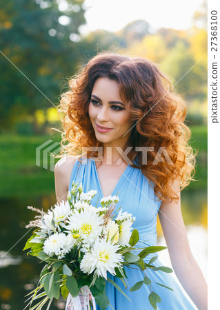 Beautiful young woman with long curly hair Beautiful young woman with long curly hair 27368100