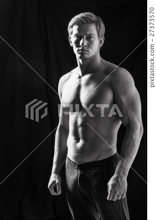 Male fitness model showing muscles in studio Male fitness model showing muscles in studio 27373570