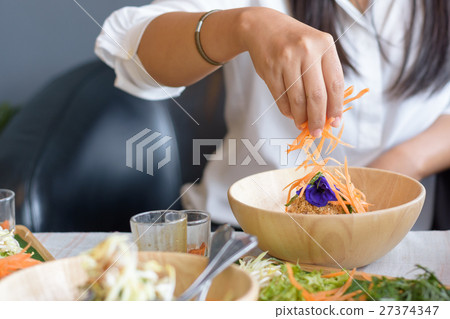 Woman mixing ingredients of Rice salad 27374347