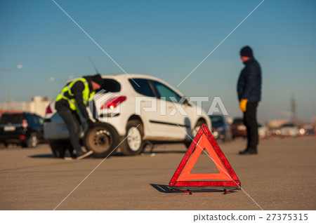 Assistance technician changing spare wheel outdoor 27375315