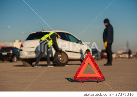 Car assistance technician changing wheel outdoors 27375316