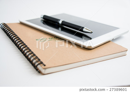 Put a pen on tablet and notebook. Put a pen on tablet and notebook. 27389601