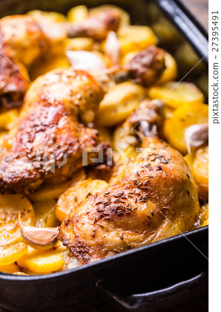 Roasted chicken leg with potatoes with caraway. 27395491
