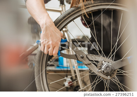 Skilled craftswoman fixing the chain of the 27396251