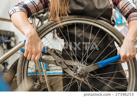 Hardworking craftswoman fixing the chain of the 27396253