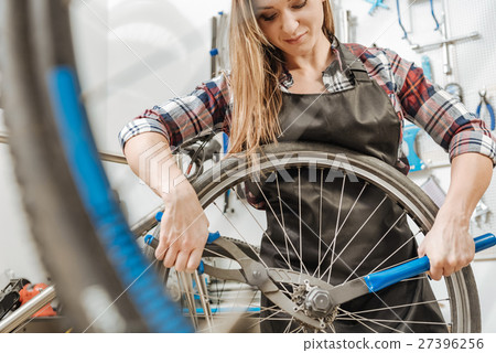 Female athletic worker fixing the chain of the Female athletic worker fixing the chain of the 27396256