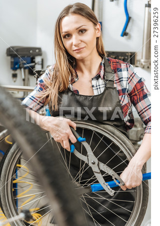 Pleasant young craftswoman working in the repair Pleasant young craftswoman working in the repair 27396259