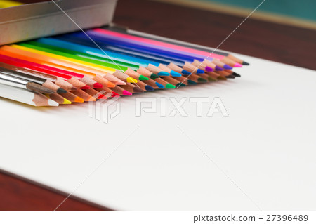 Multicolored pensils in the box on a wooden table. 27396489