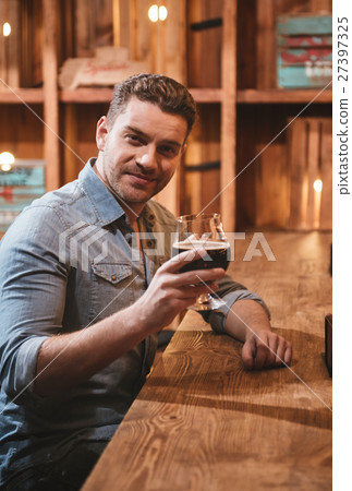 Positive handsome man holding a glass with Positive handsome man holding a glass with 27397325