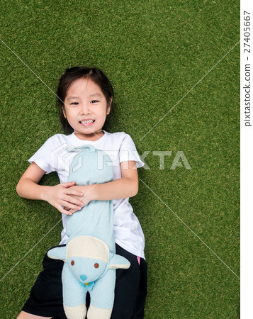 little asian kid girl lay down on the lawn  27405667