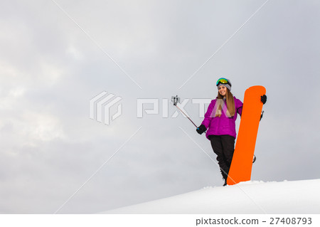 Young woman with the snowboard shooting a selfie  27408793