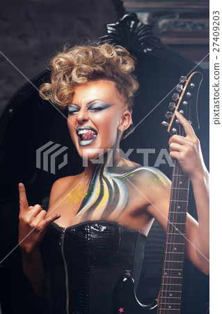 Impressed woman punk showing metal horns 27409203