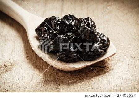 dried plums prunes on wooden spoon dried plums prunes on wooden spoon 27409657