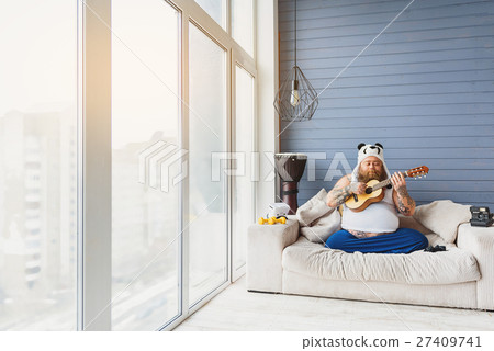 Thick guy playing guitar at home Thick guy playing guitar at home 27409741