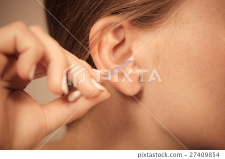 Woman cleaning ear with cotton swabs closeup 27409854