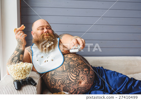 Lazy thick guy watching tv at home 27410499