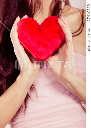 woman holds red heart in hand closeup 27410560