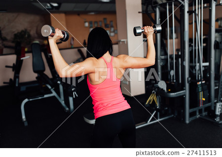 Sporty girl doing exercise with dumbbells. 27411513