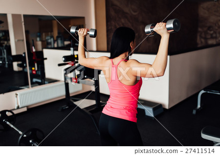 Sporty girl doing exercise with dumbbells. 27411514