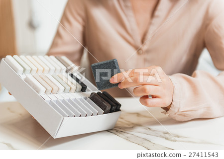 Shop assistant showing design products Shop assistant showing design products 27411543