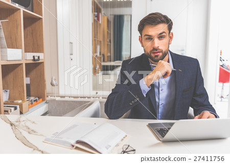 Serious male assistant selling design objects Serious male assistant selling design objects 27411756