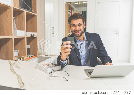 Joyful salesman proposing design object Joyful salesman proposing design object 27411757