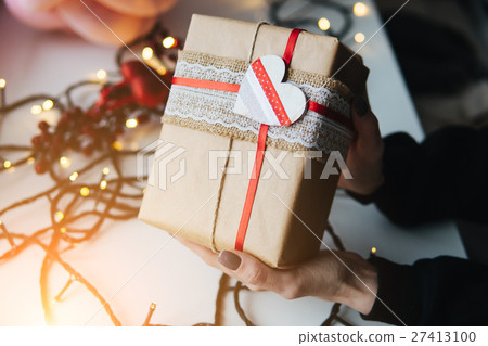 girl holding a Christmas gift in hand 27413100