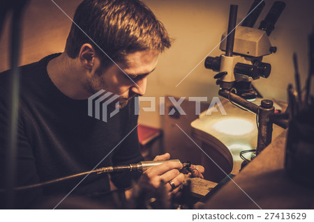 Jeweler at work in jewelery workshop Jeweler at work in jewelery workshop 27413629