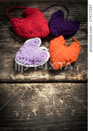 Colorful knitted hearts on the dark old boards Colorful knitted hearts on the dark old boards 27417887