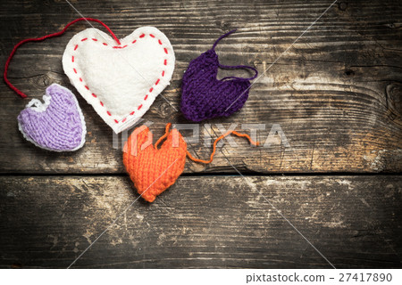 Colorful knitted hearts on the dark old boards Colorful knitted hearts on the dark old boards 27417890