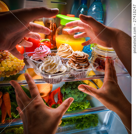 Human hands reaching for sweet cake at night Human hands reaching for sweet cake at night 27418247