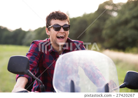 Young man enjoying a motorbike ride in countryside 27420267