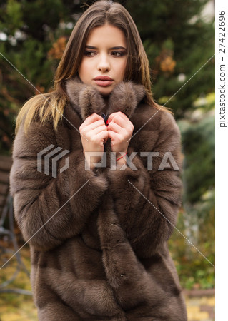 Pretty teen girl is wearing fur coat Pretty teen girl is wearing fur coat 27422696