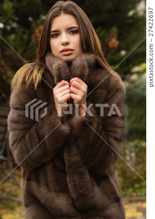 Pretty teen girl is wearing fur coat Pretty teen girl is wearing fur coat 27422697